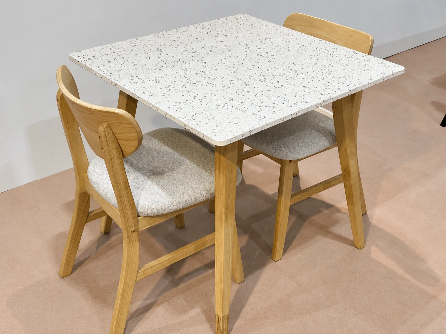 Actual terrazzo-look table top photographed with wooden dining chairs